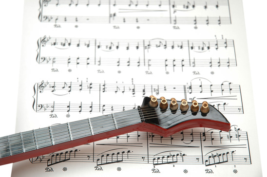 Rock guitar over the sheet of printed music